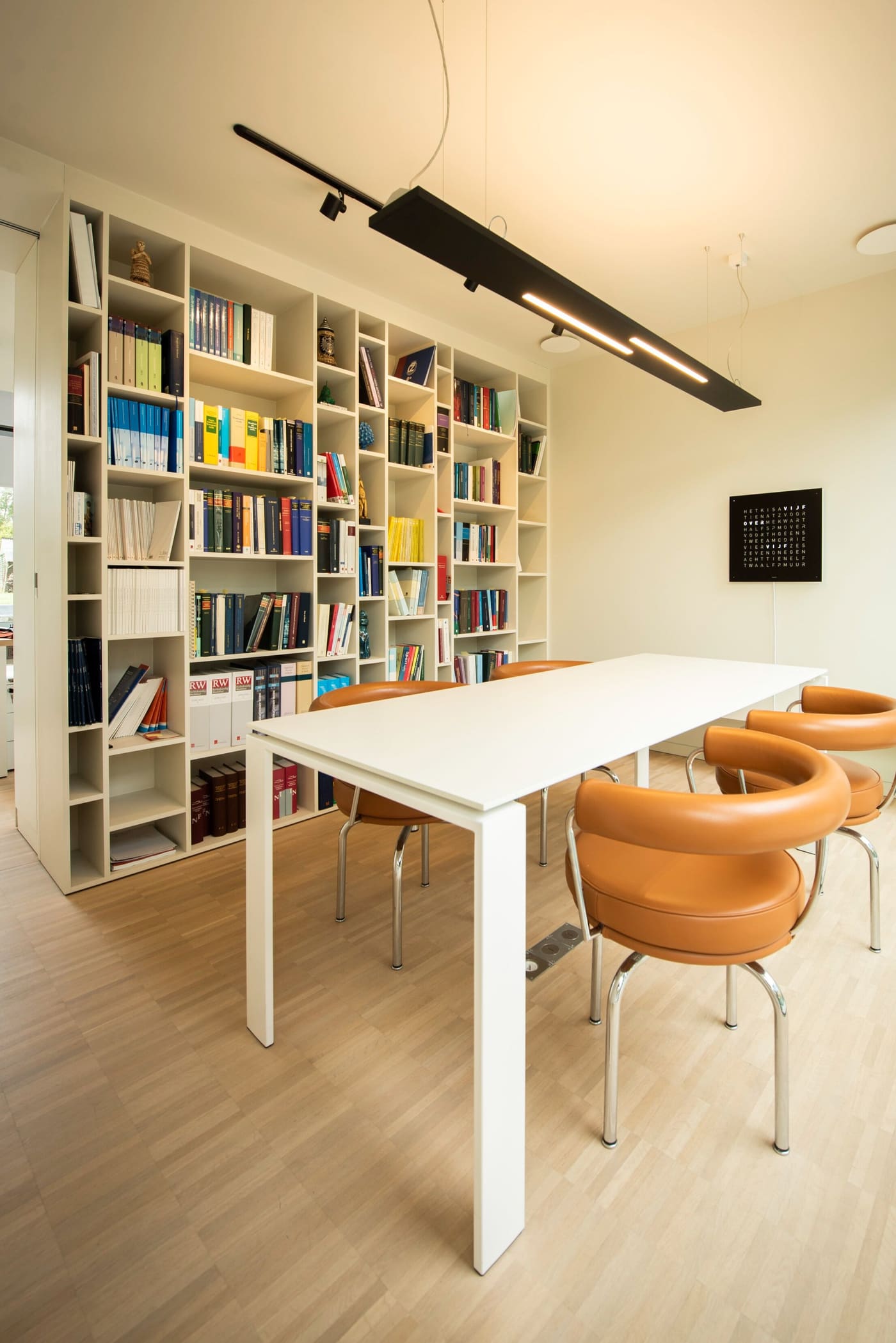 De vergadertafel en bibliotheek van het kantoor in Brugge
