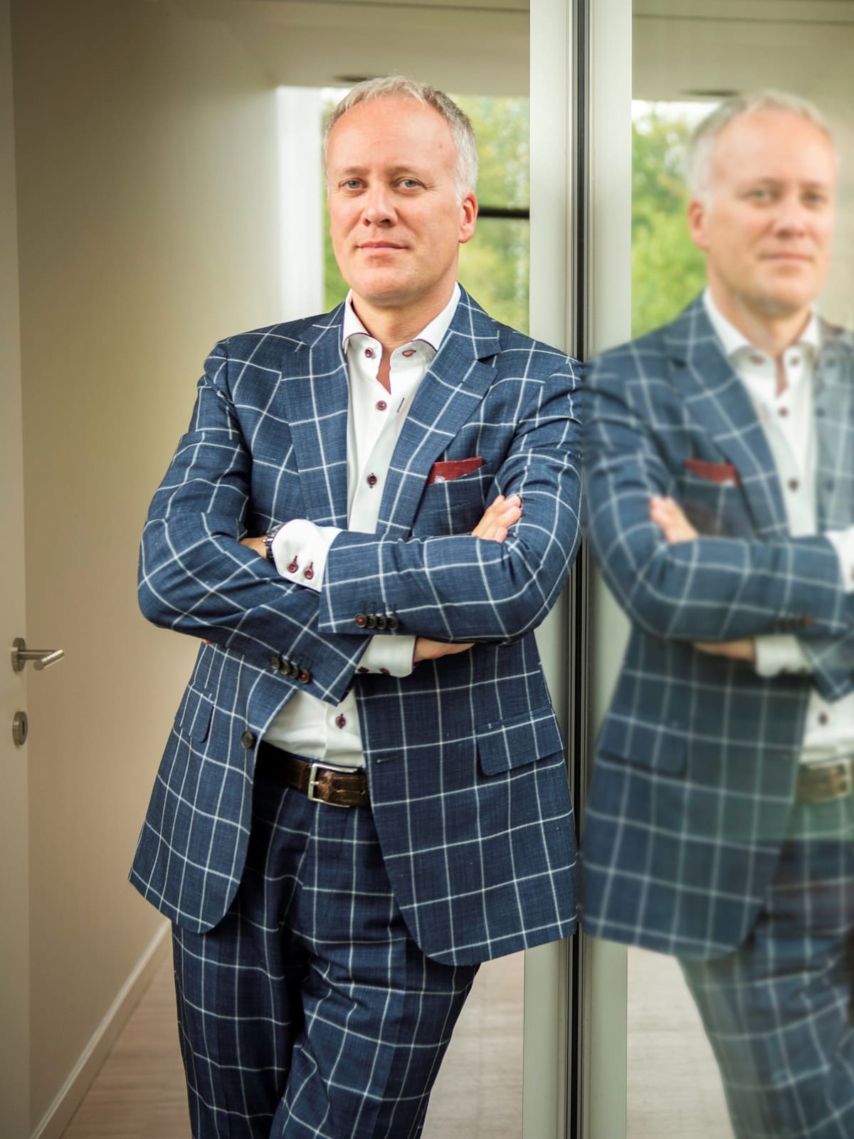 Filip Melis, advocaat-vennoot bij Melis Advocaten, staand tegen de glazen gevel van het kantoor